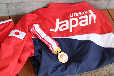 「第29回全日本ライフセービング種目別選手権」で勝ち取ったメダルとユース日本代表のジャージ。フル代表は「Japan」の文字がすべて大文字になるとか。目指せ大文字！