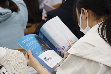 パンフレットを片手に説明を聞く高校生