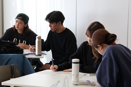 メモを取りながら、集中して耳を傾ける学生たち